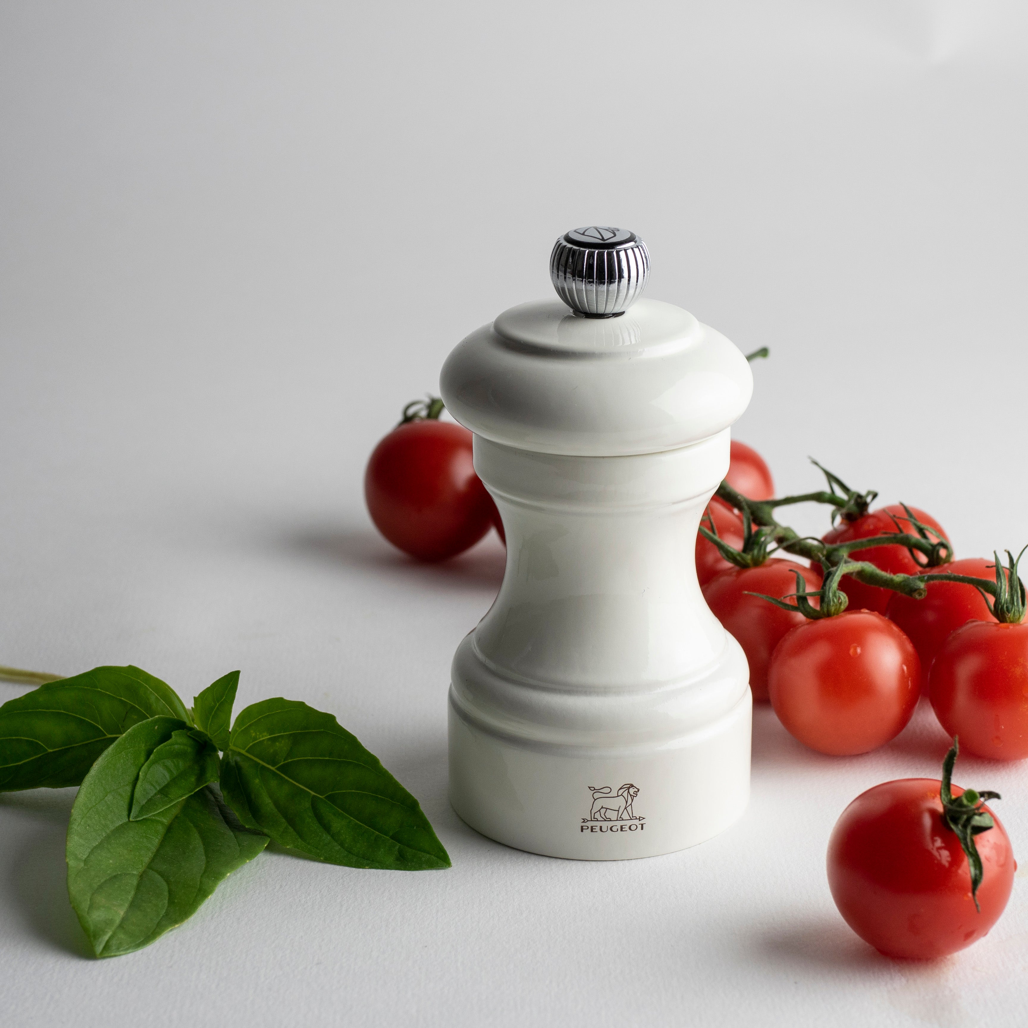Peugeot Pfeffermühle weiß mit Tomaten und Basilikum im Hintergrund