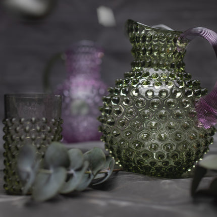 Anna von Lipa Hobnail Karaffe Olivgrün-Lila auf gedecktem Tisch